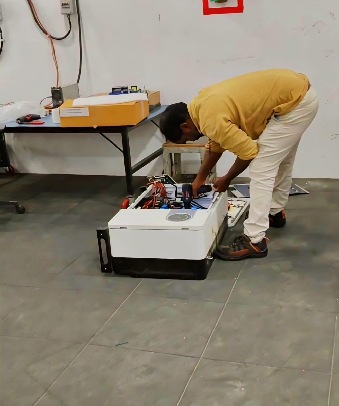 Technician repairing a solar inverter on the service floor