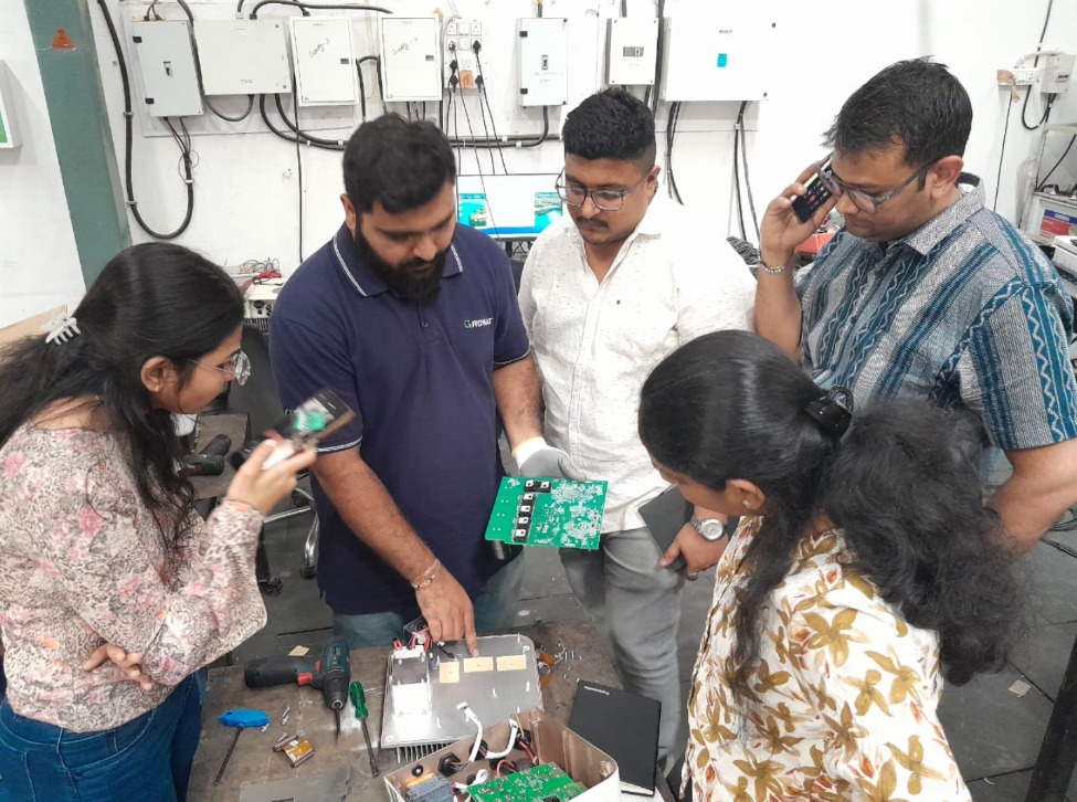 Team inspecting solar inverter electronics during technical diagnosis