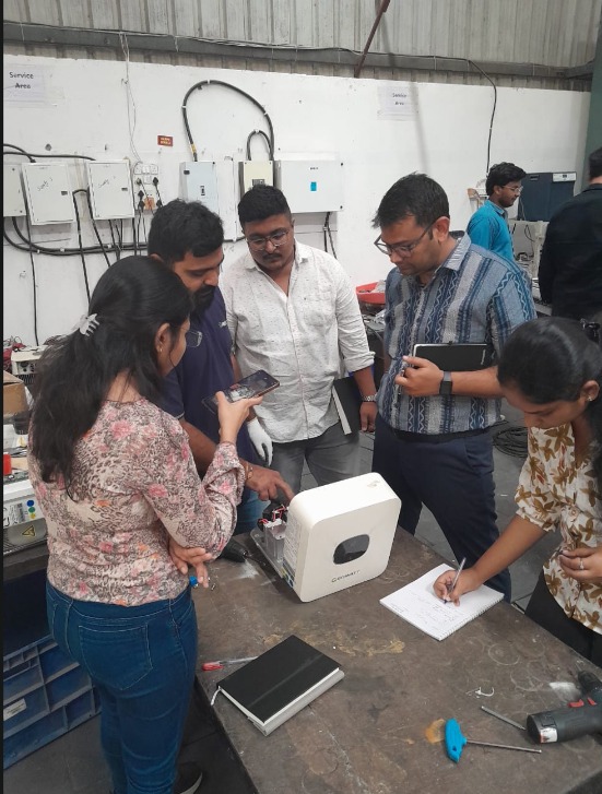 Team documenting and inspecting an inverter on the service floor