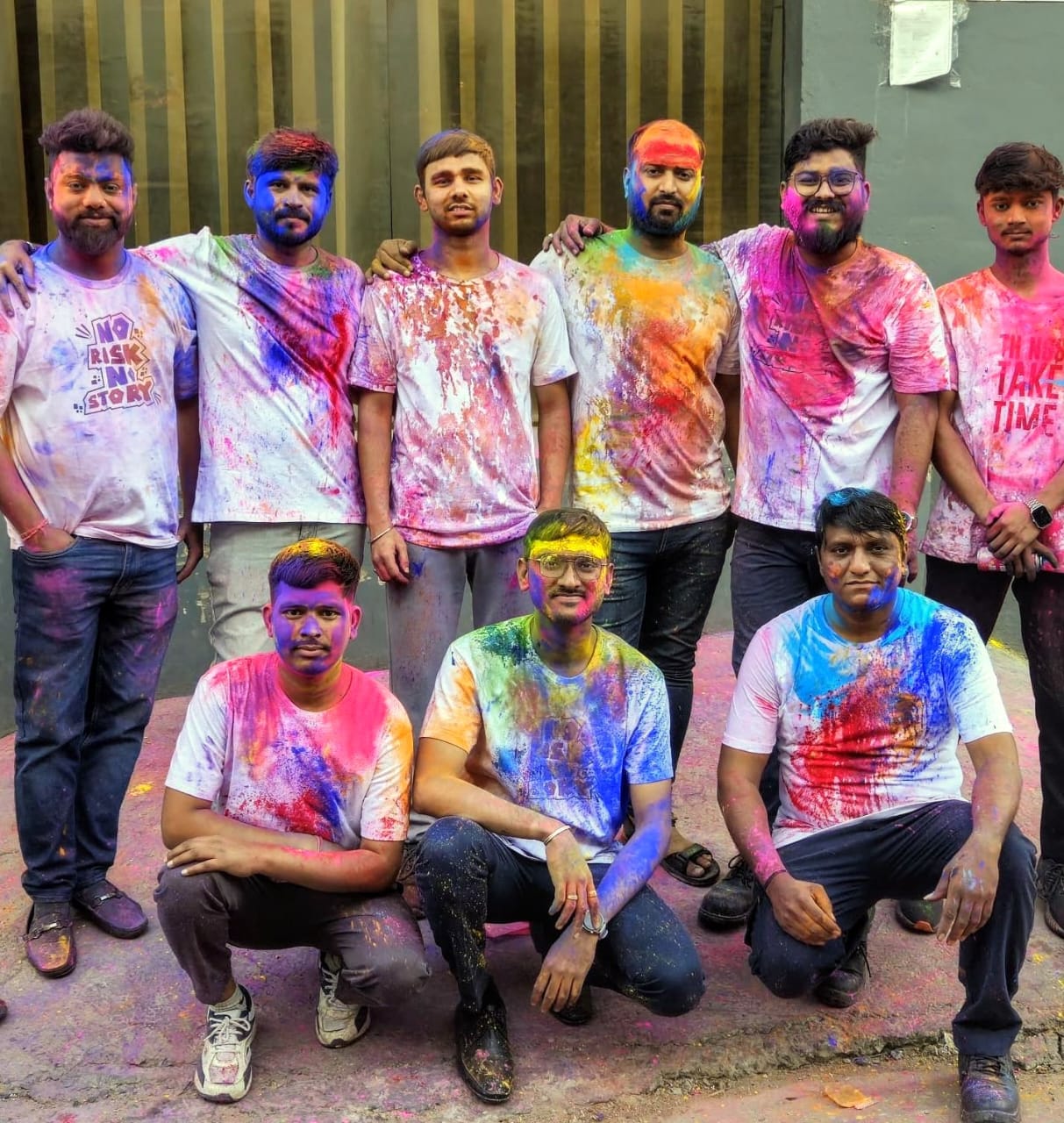 Team celebrating Holi outdoors with colorful powder