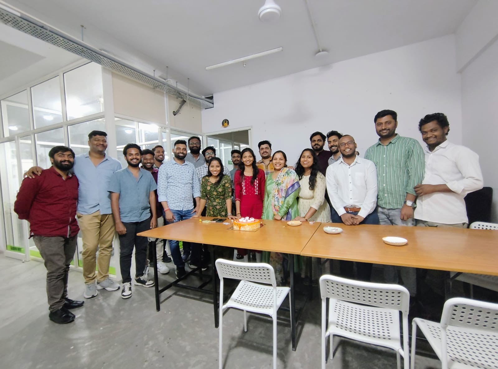 Gajra New Energy team gathered around a cake in the office